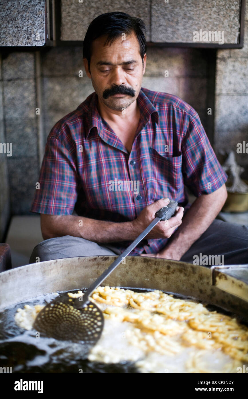 Ein Mann Pommes frites Teig Jalebis an der alten und berühmten Jalebi Wala (an der Ecke Dariba Kalan und Chandni machen Stockfoto