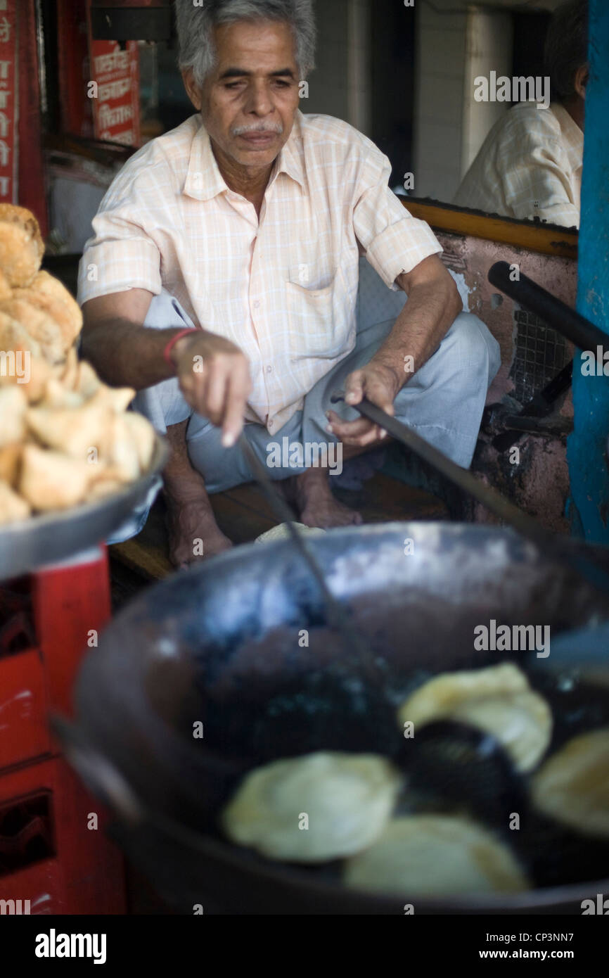 Ein Mann Pommes Brot in einer großen Pfanne in einem Stall in Chadni Chowk, New Delhi, Indien Stockfoto