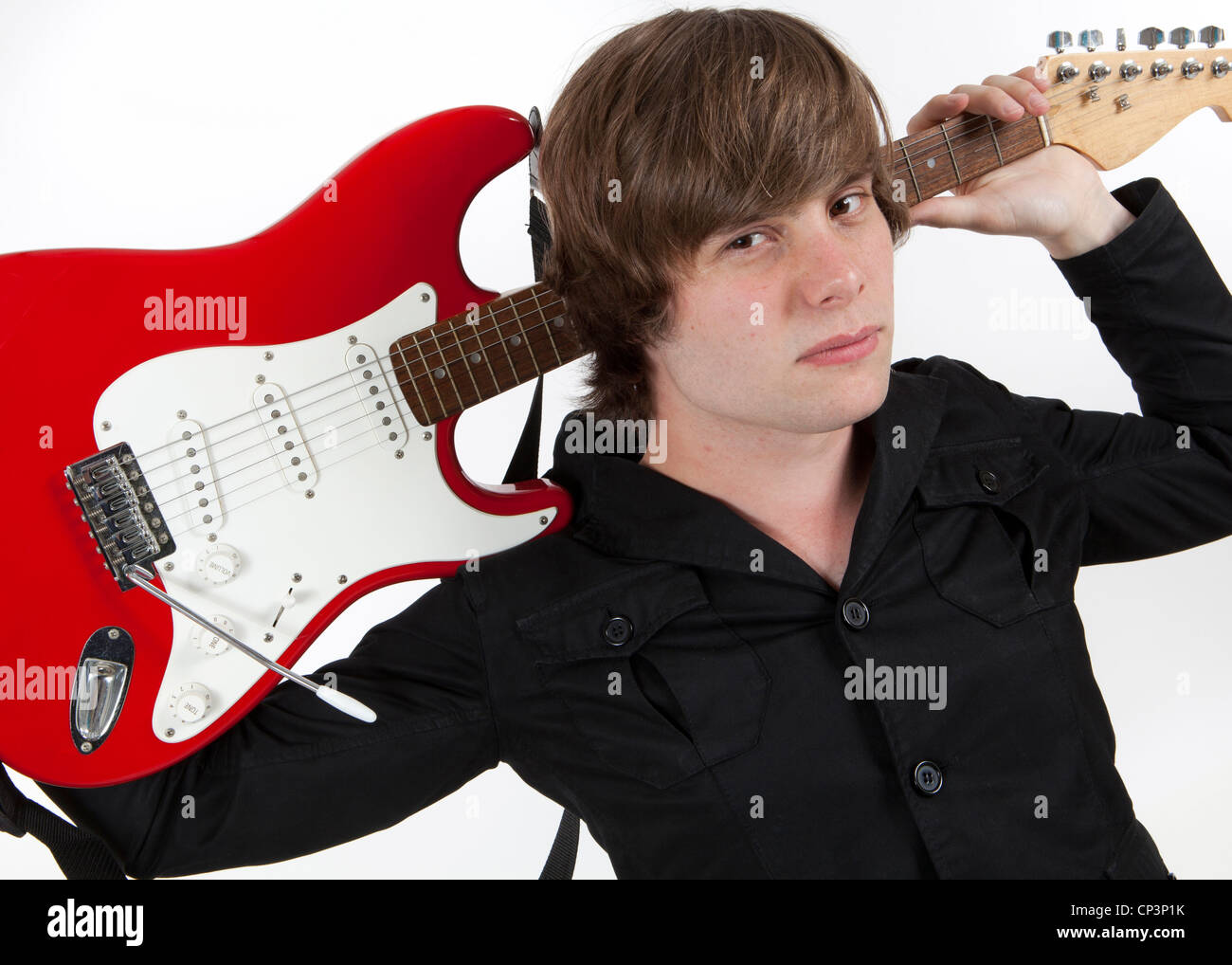 Halbe Länge Farbe Studioportrait von Mann, dunkles Hemd hält eine rote e-Gitarre hinter seinen Kopf auf seinen Schultern trägt Stockfoto