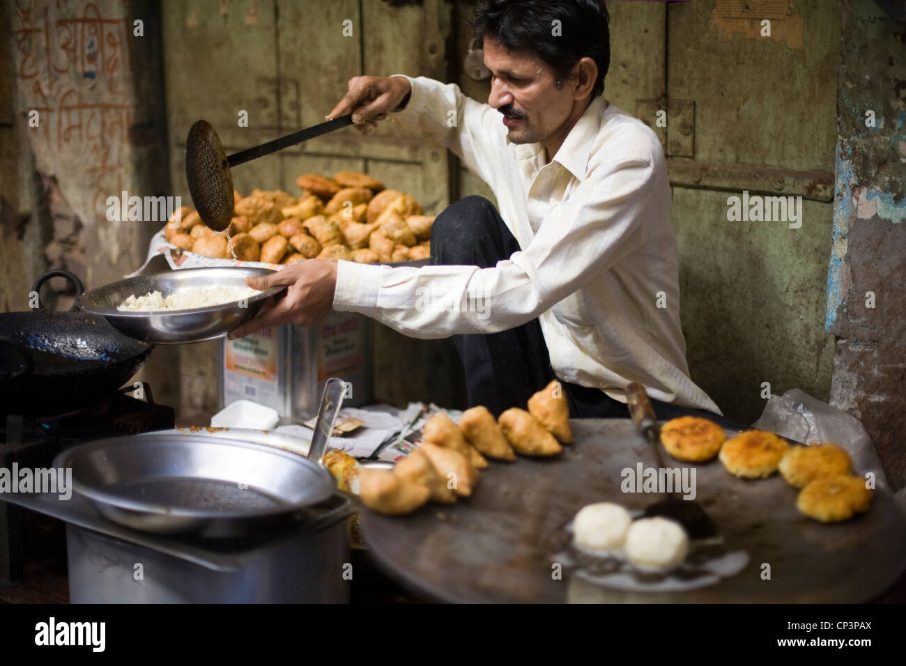Ein Mann Kochen und servieren Gebratene Kartoffel-Snacks auf den Straßen des Johari Bazaar, Jaipur, Indien Stockfoto