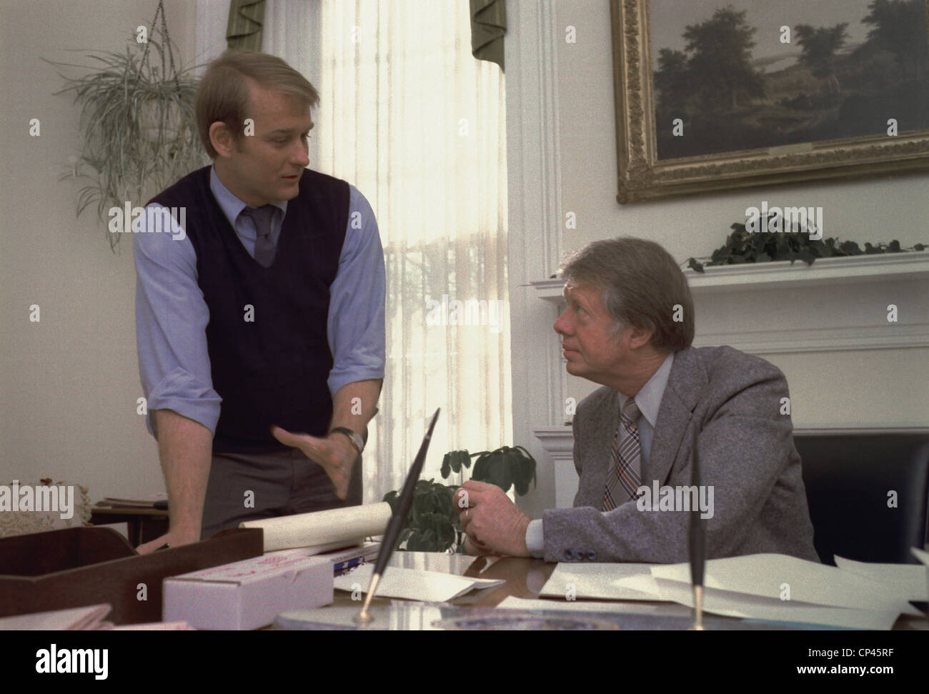 Präsident Carter und seinen Pressesprecher Jody Powell im Gespräch in das Weiße Haus Oval Office. Ca. 1977-1980. Stockfoto