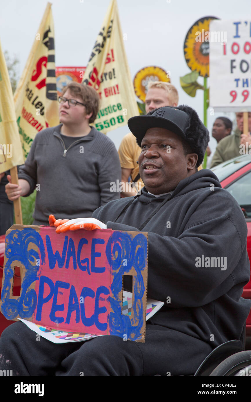 Detroit, Michigan - ein afrikanisch-amerikanischer Mann in einem Rollstuhl mit einem Friedenszeichen war Teil eines Mai und Rallye. Stockfoto