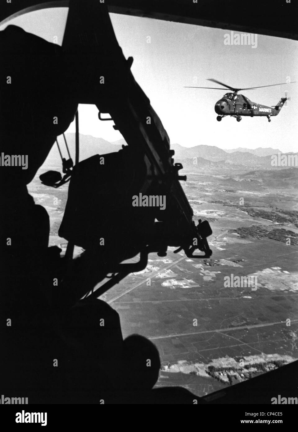 Vietnam-Krieg. US Armee-Hubschrauber im Flug hinter der Tür Schütze eines Hubschraubers Begleiter angesehen. Ca. 1965. Stockfoto