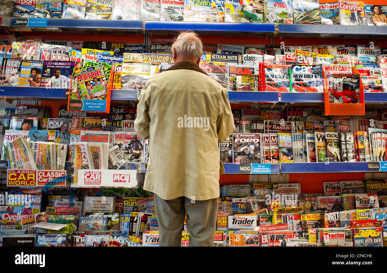 Rückansicht eines Mannes stehen und Lesen von Zeitschriften in einem Zweig der W H Smith Zeitschriftenhandel, UK Stockfoto
