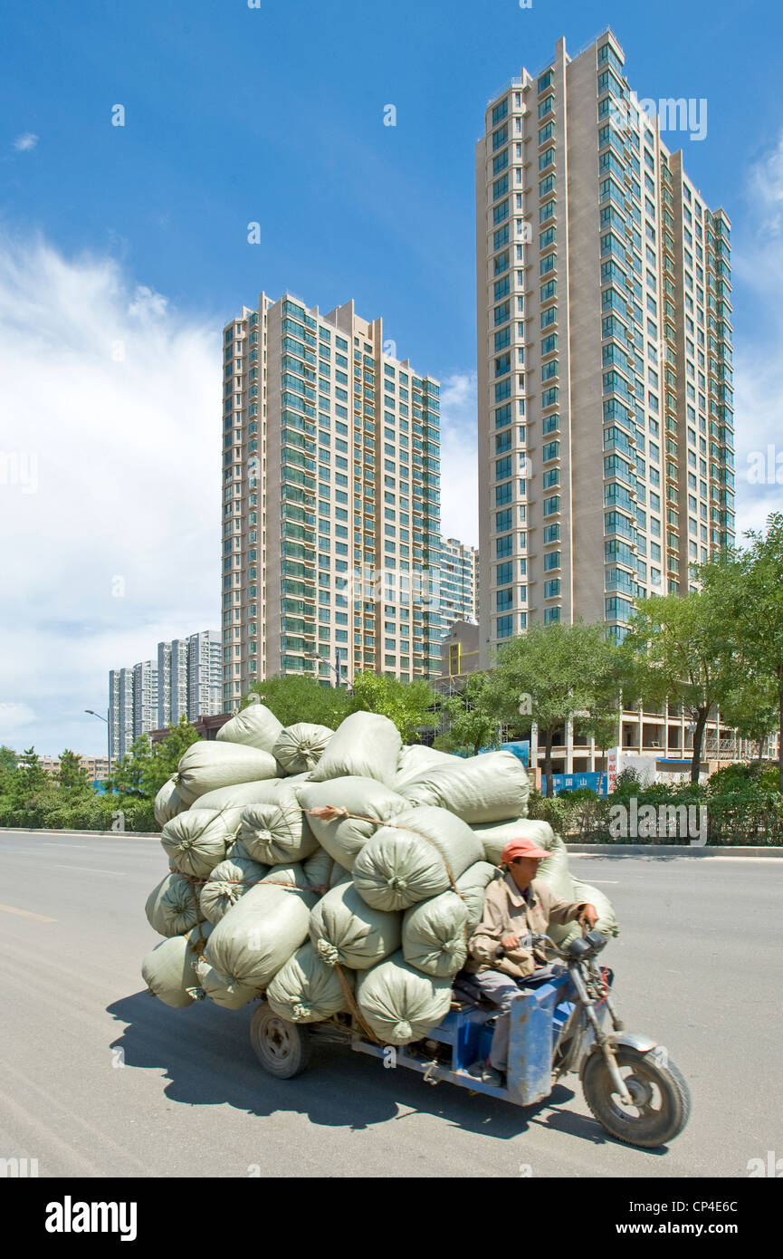 Ein Dreirad mit Gütern, die an einer der Hauptstraßen in Datong unterwegs. Stockfoto