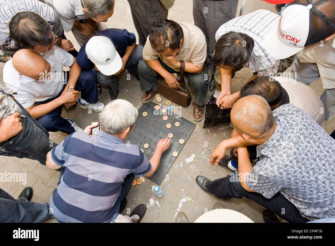Lokale Leute spielen Xiangqi (Chinesisches Schach) auf der Straße beim Zuschauer sehen das Spiel. Stockfoto