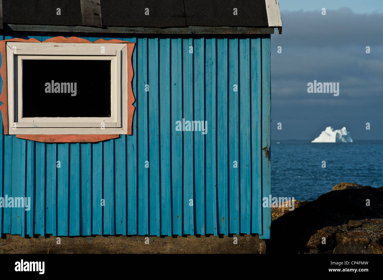 Grönland - Westküste - Qaasuitsup Kommunia - Upernavik. Haus und Eisberg auf dem Hintergrund. Stockfoto