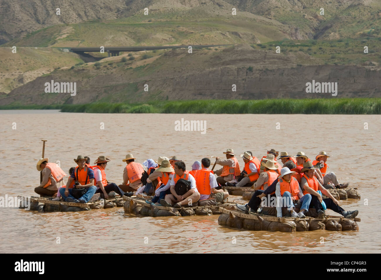Chinesische Touristen reisen entlang des gelben Flusses auf traditionelle Schaffell Flößen - eines der "Fahrten" im Shapatou Themenpark. Stockfoto