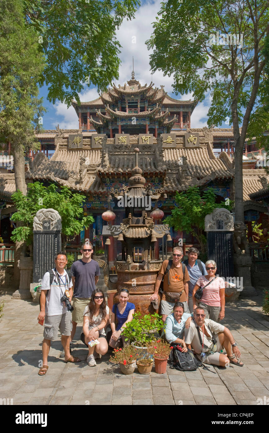 Eine Gruppe von europäischen Touristen am Haupteingang an der Gao Miou Tempelanlage in Zhongwei. Stockfoto