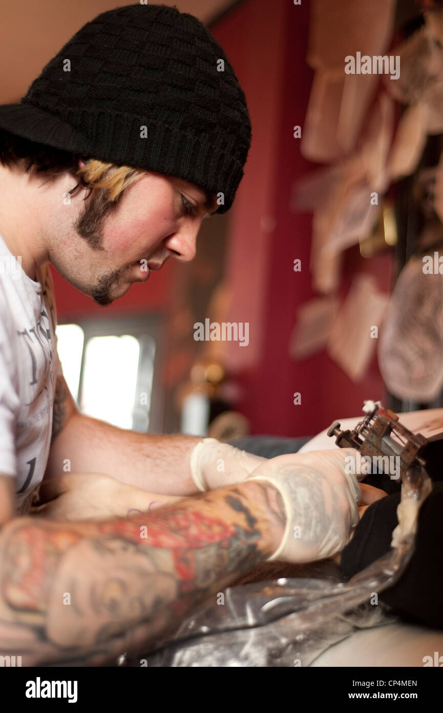 Professionelle tattoo Artist robin Stephens bei der Arbeit Stockfoto
