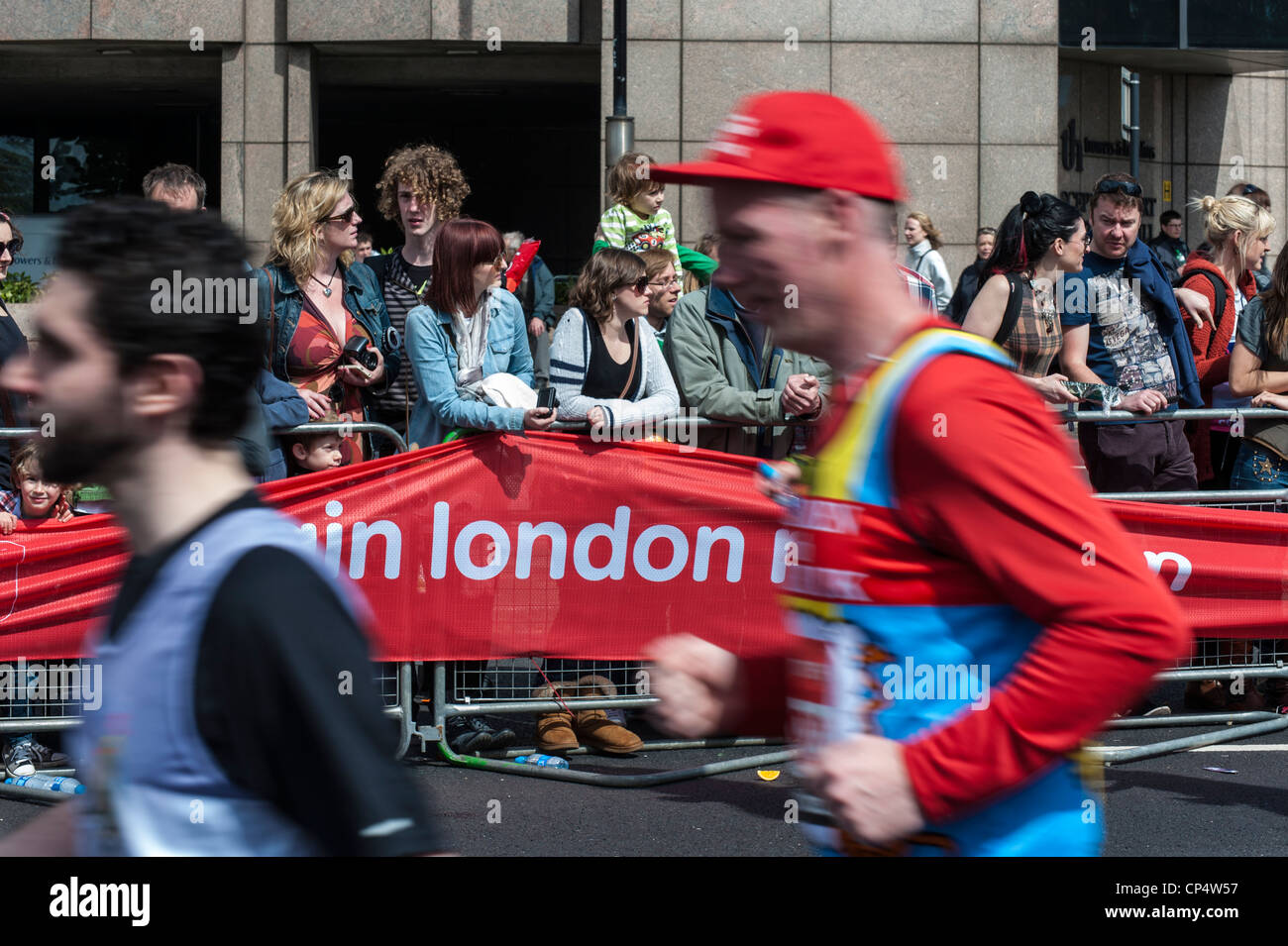 Läufer im Vereinigten 2012 Virgin London Marathon. Läufer mit Motion blur vor London Marathon Banner und Zeichen Stockfoto