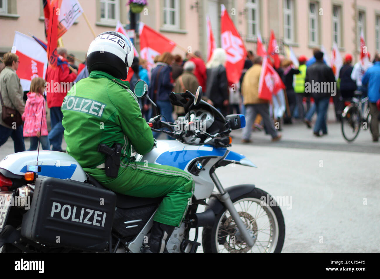 Polizist auf dem Motorrad bietet Sicherheit für die Demonstranten. Stockfoto