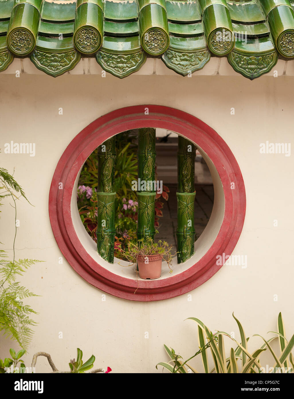 ein rundes vergitterten Fenster im Hintergrund Wand Stockfoto