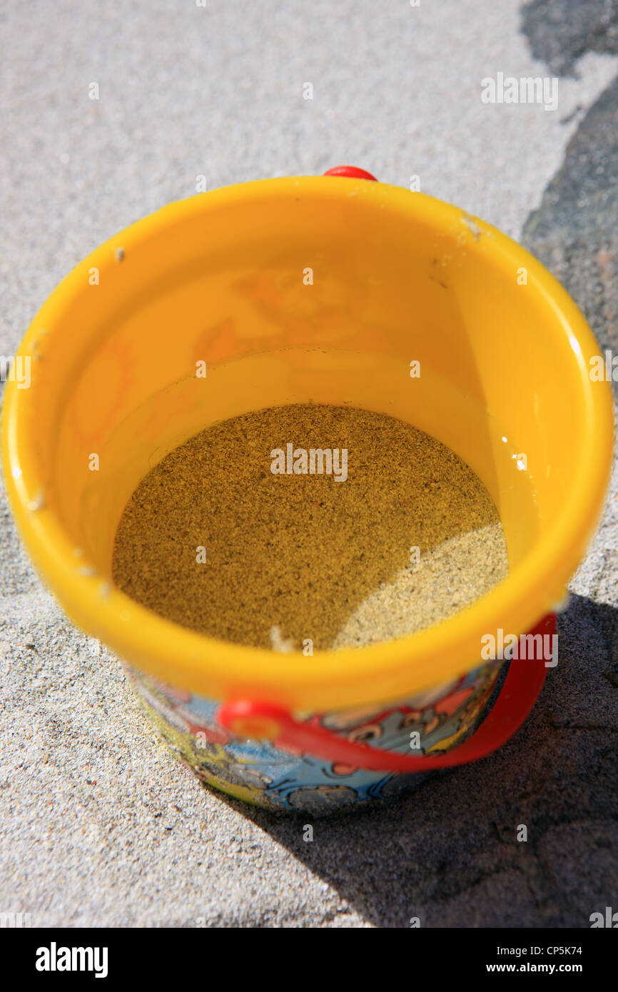Childs gelb Eimer an einem Sandstrand Stockfoto