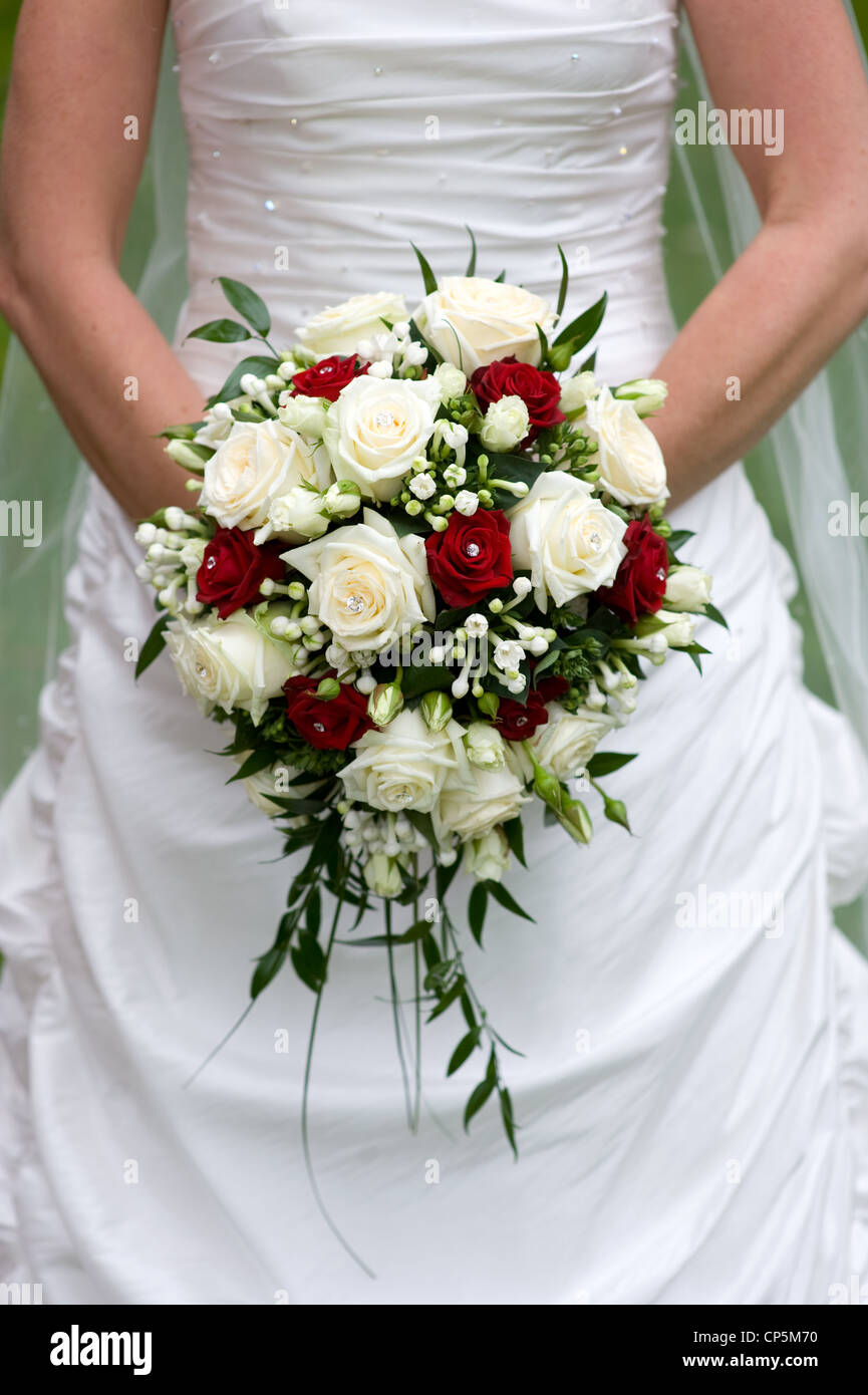Braut hält einen Blumenstrauß an ihrem Hochzeitstag Stockfoto