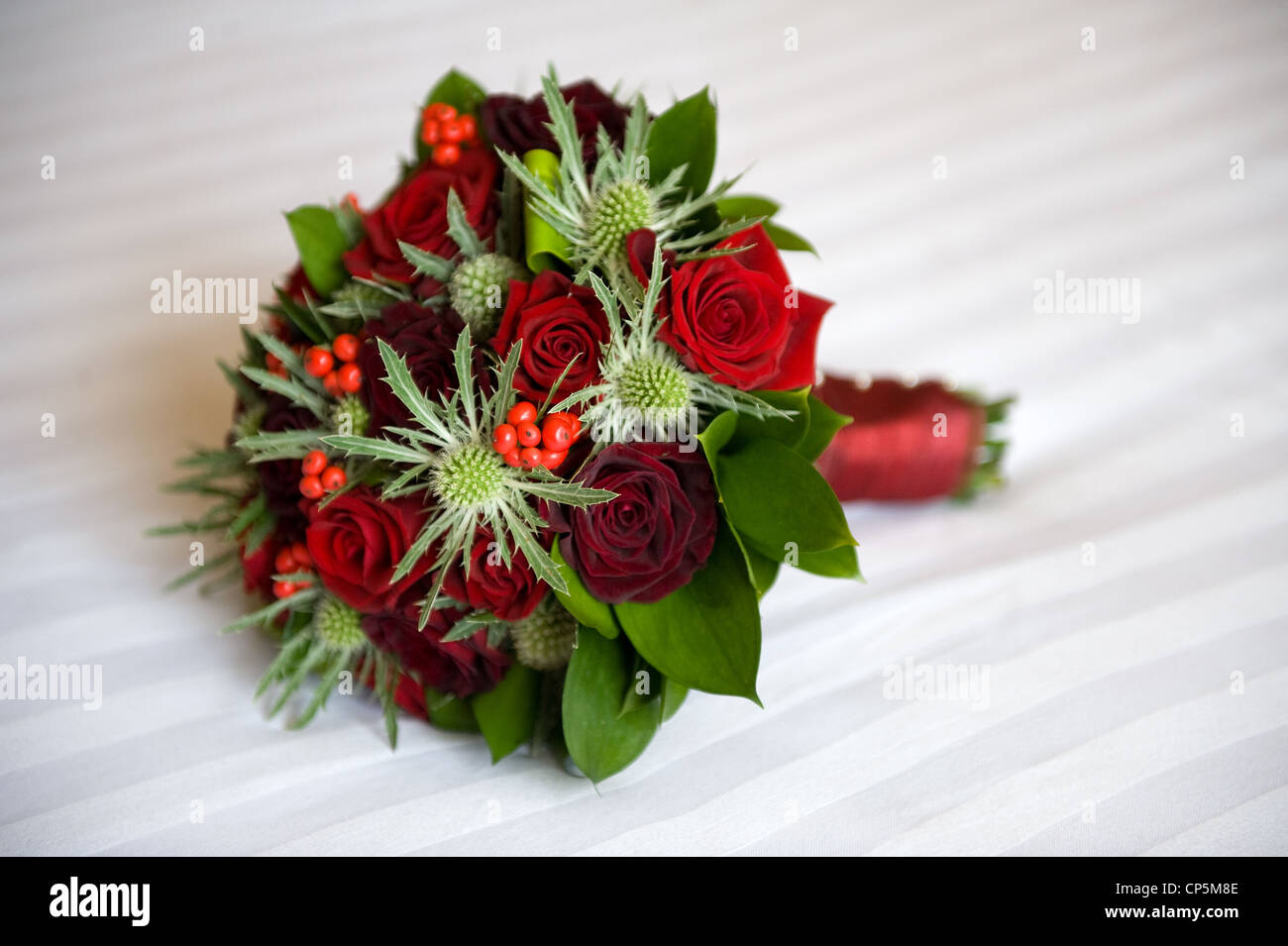 eine Hochzeit Bouquet von roten Rosen und eryngium Stockfoto