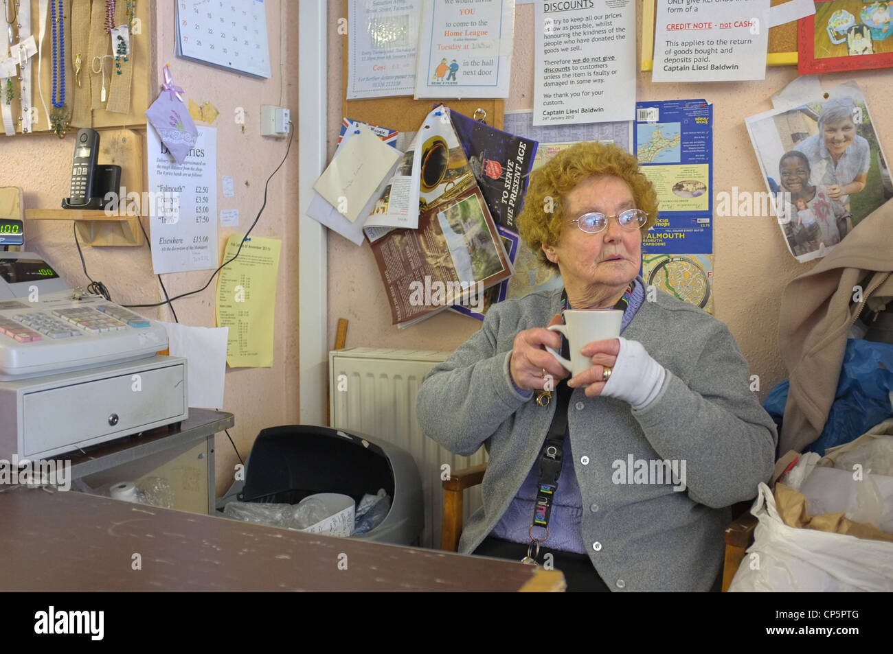 Ein Helfer in der Heilsarmee-Charity-Shop in Falmouth, Cornwall Stockfoto