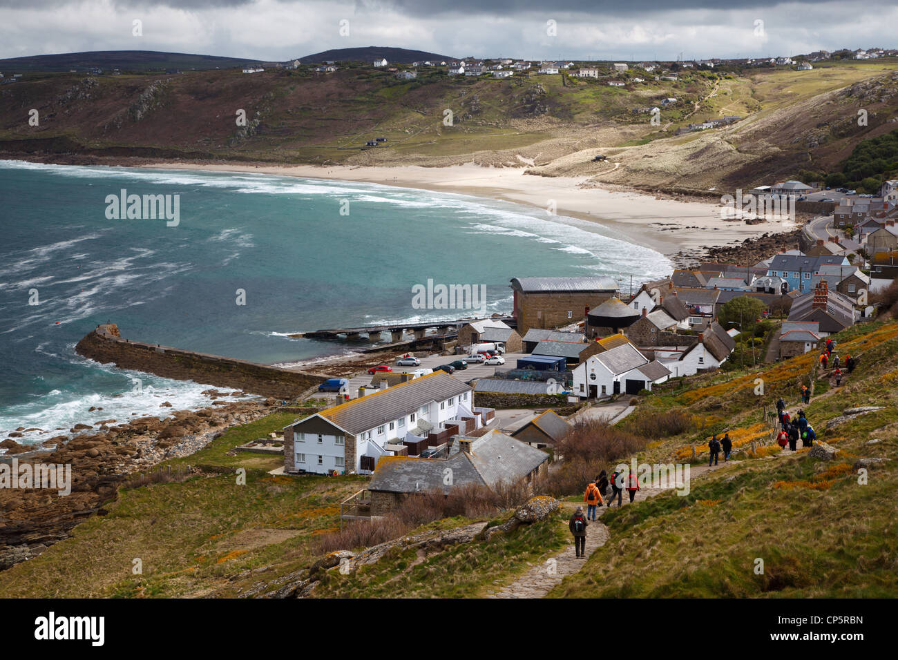 Menschen zu Fuß entlang des South West Coast Path in Sennen Cove cornwall England mit Blick auf whitesand Bay und der Sandstrand Stockfoto