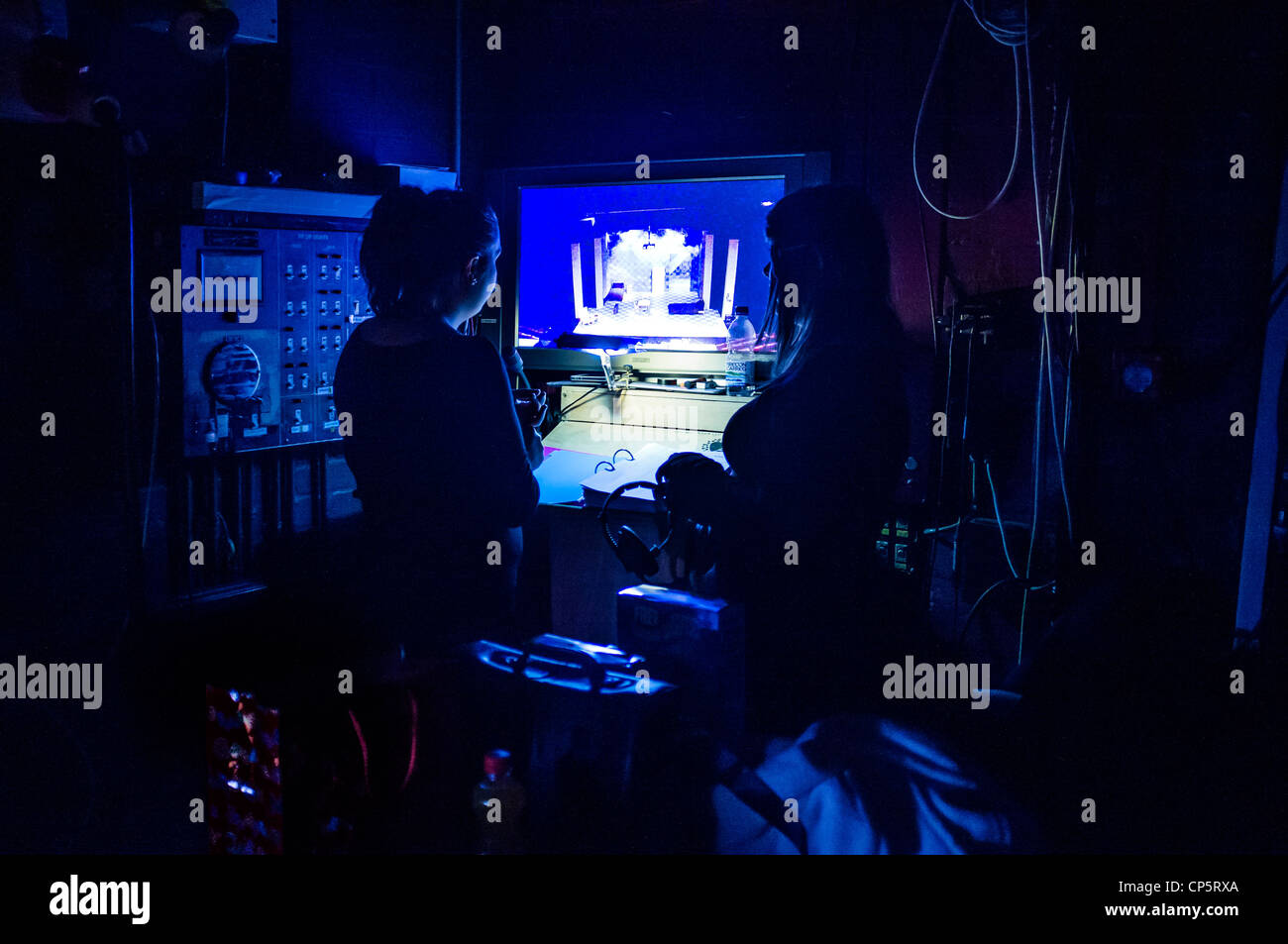 Zwei Frauen Inspizienten in den Flügeln einer Theaterproduktion Blick auf einem Videomonitor der Performance, UK Stockfoto