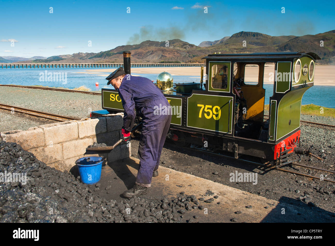 Eine Betankung der Fairbourne Miniatur-Dampfeisenbahn Lokführer mit Kohle, Cadair Idris Berg im Hintergrund, Gwynedd, Wales Stockfoto