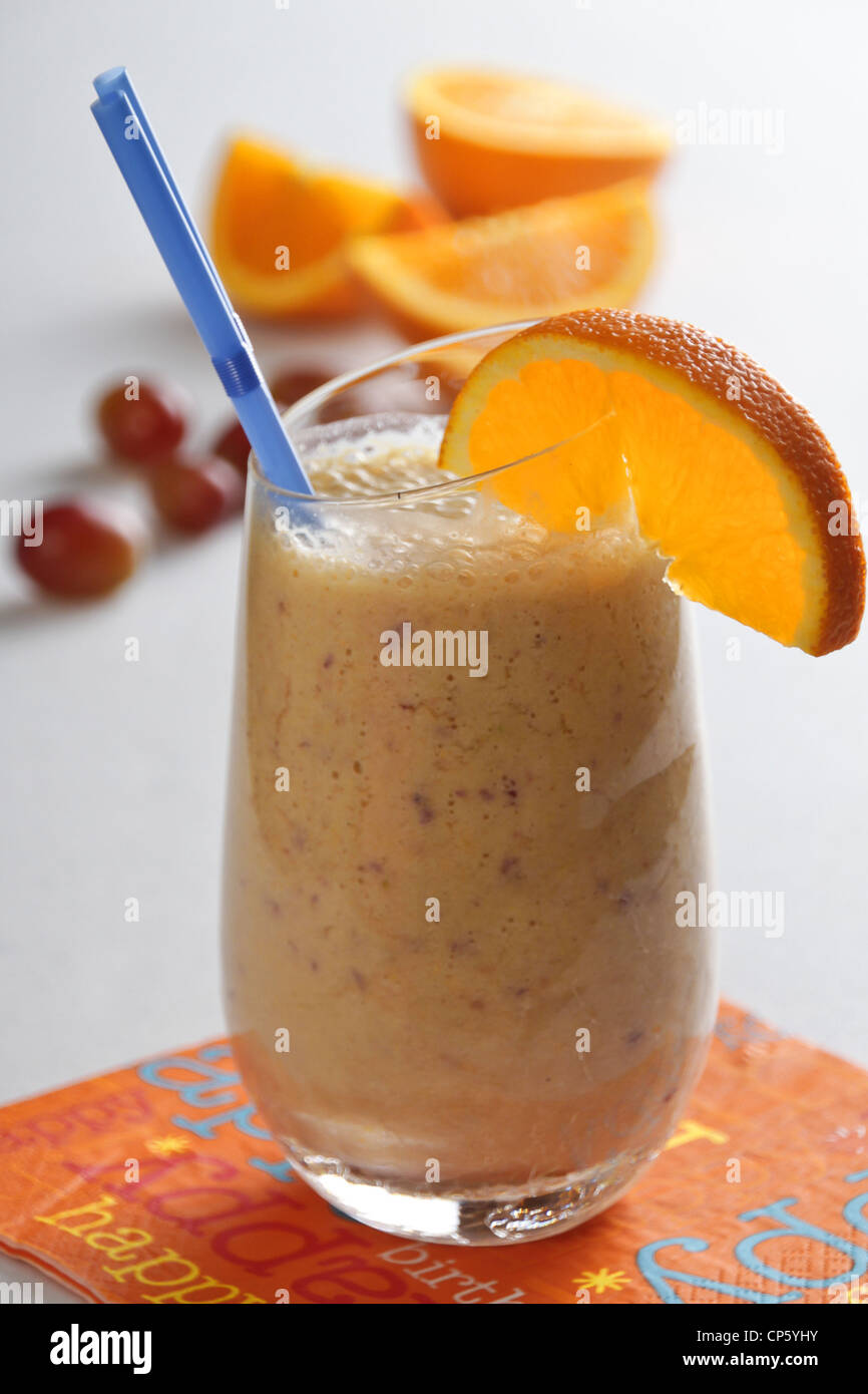 Eine Traube und orange Smoothie in ein klares Glas mit einem weißen Hintergrund. Stockfoto