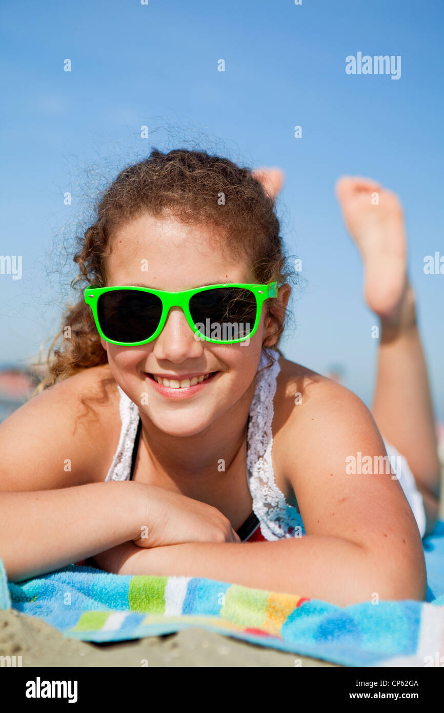 Glücklich junger Teenager Handauflegen ein Strandtuch am Meer Stockfoto