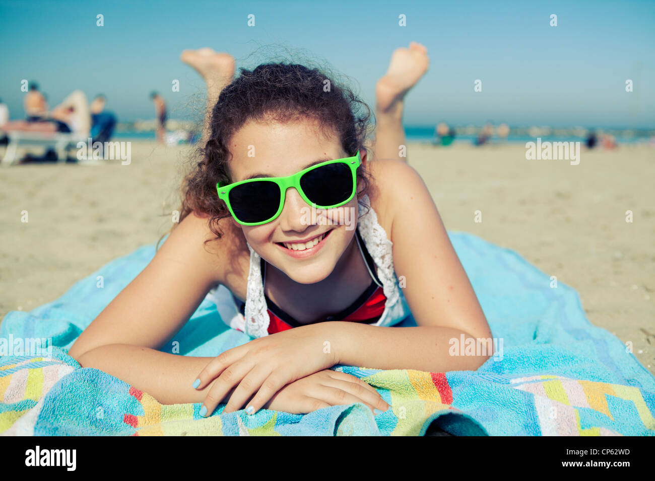 Glücklich junger Teenager Verlegung auf einem Badetuch am Strand von Rimini, Italien Stockfoto
