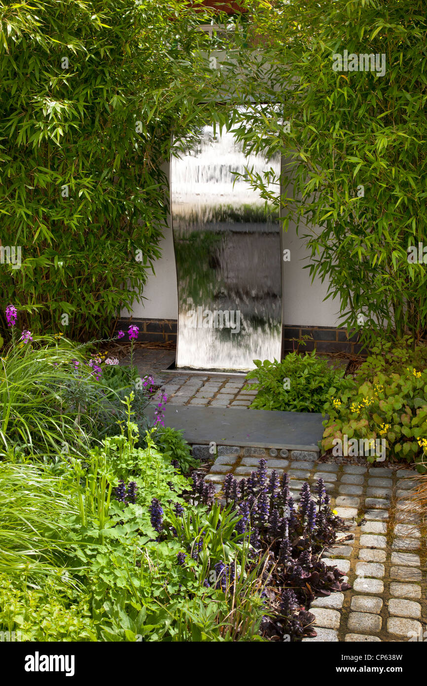 Stahlwand Wasserspiel im modernen zeitgenössischen Englischen Garten Stockfoto