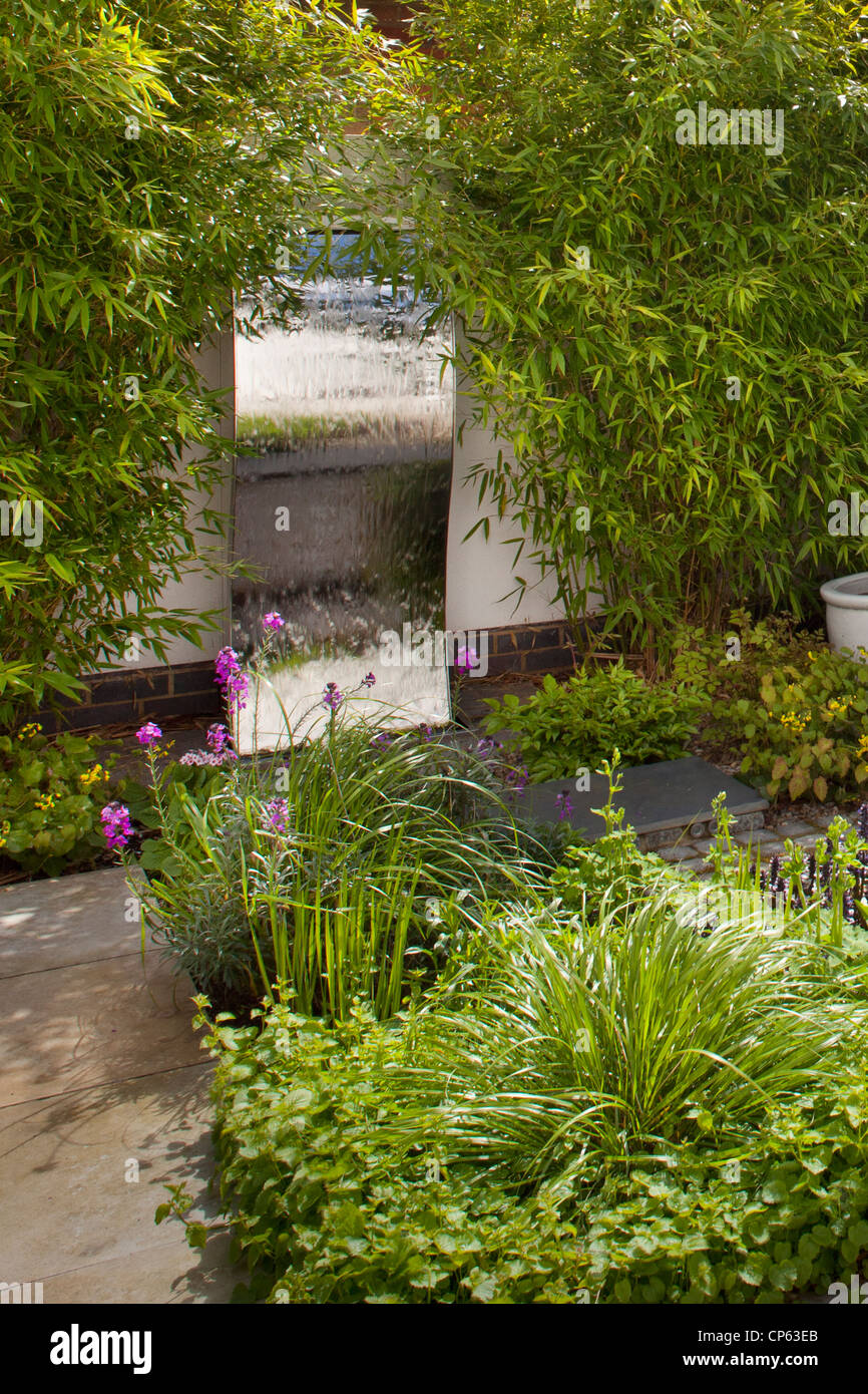 Stahlwand Wasserspiel im modernen zeitgenössischen Englischen Garten Stockfoto