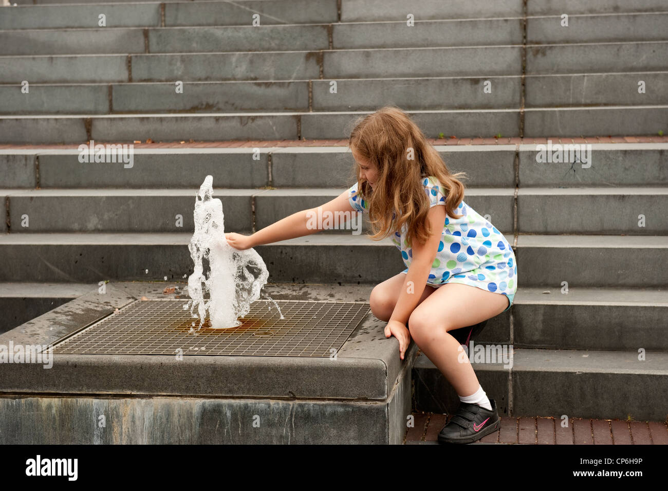 Mädchen spielen mit öffentlichen Brunnen Genk Belgien Europa EU veröffentlicht voll Modell Stockfoto