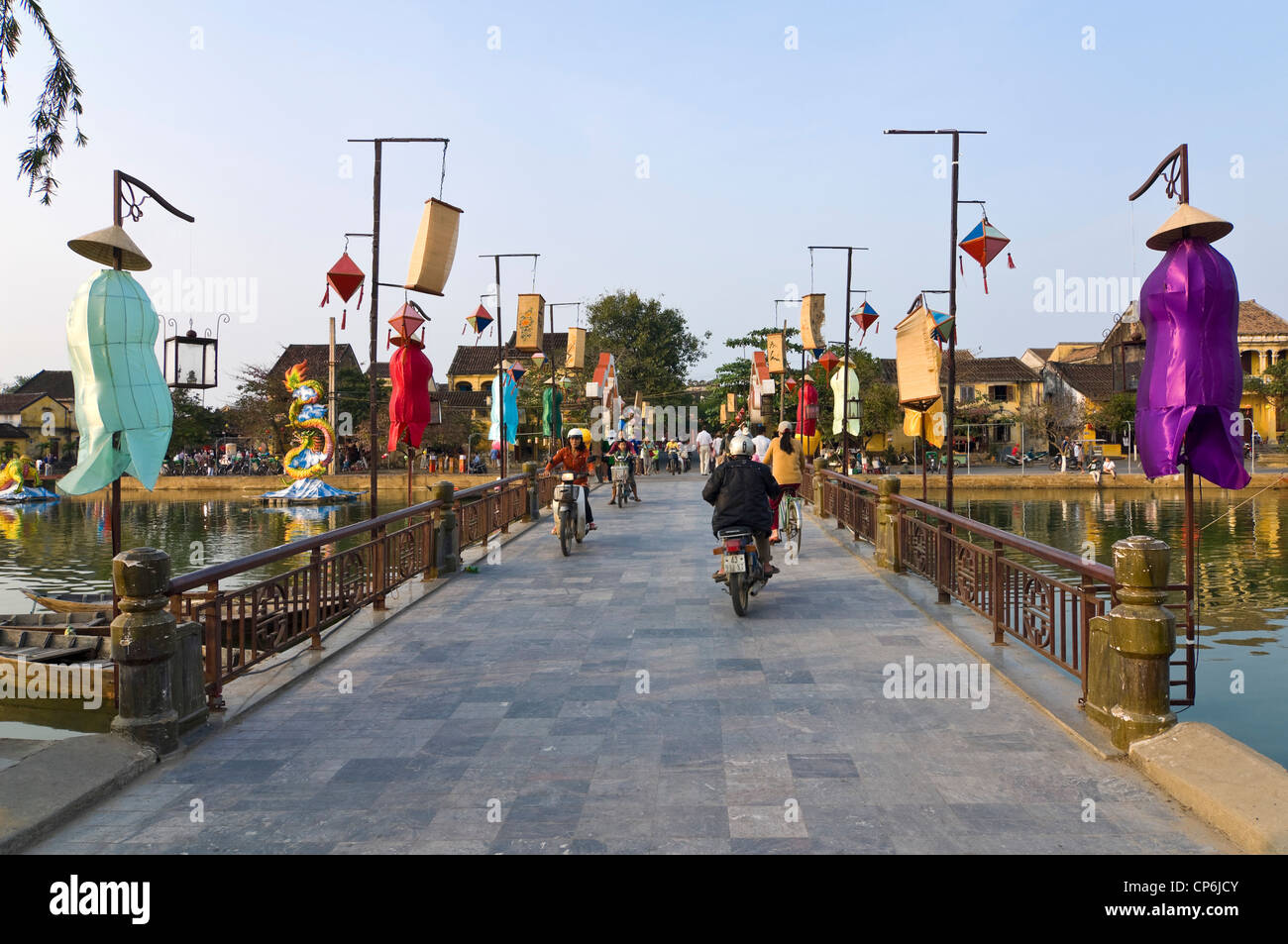 Horizontale Ansicht von Mopeds, Motorräder und Fahrräder der dekorierten Thu Bon Fluss Brücke in Hoi an Old Town. Stockfoto