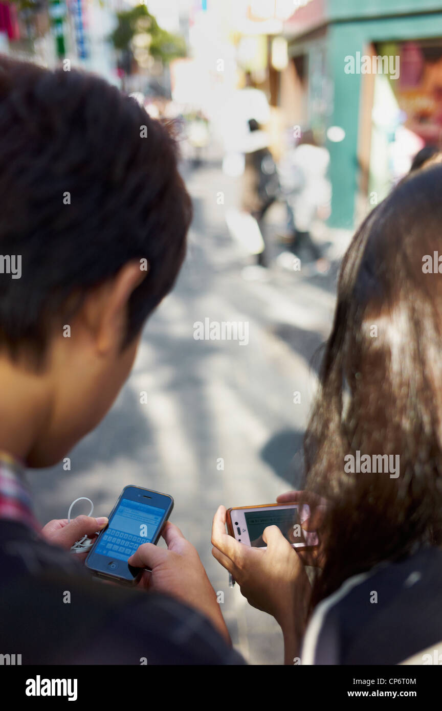 Koreanische Jugend spielt mit ihren Smartphones. Stockfoto