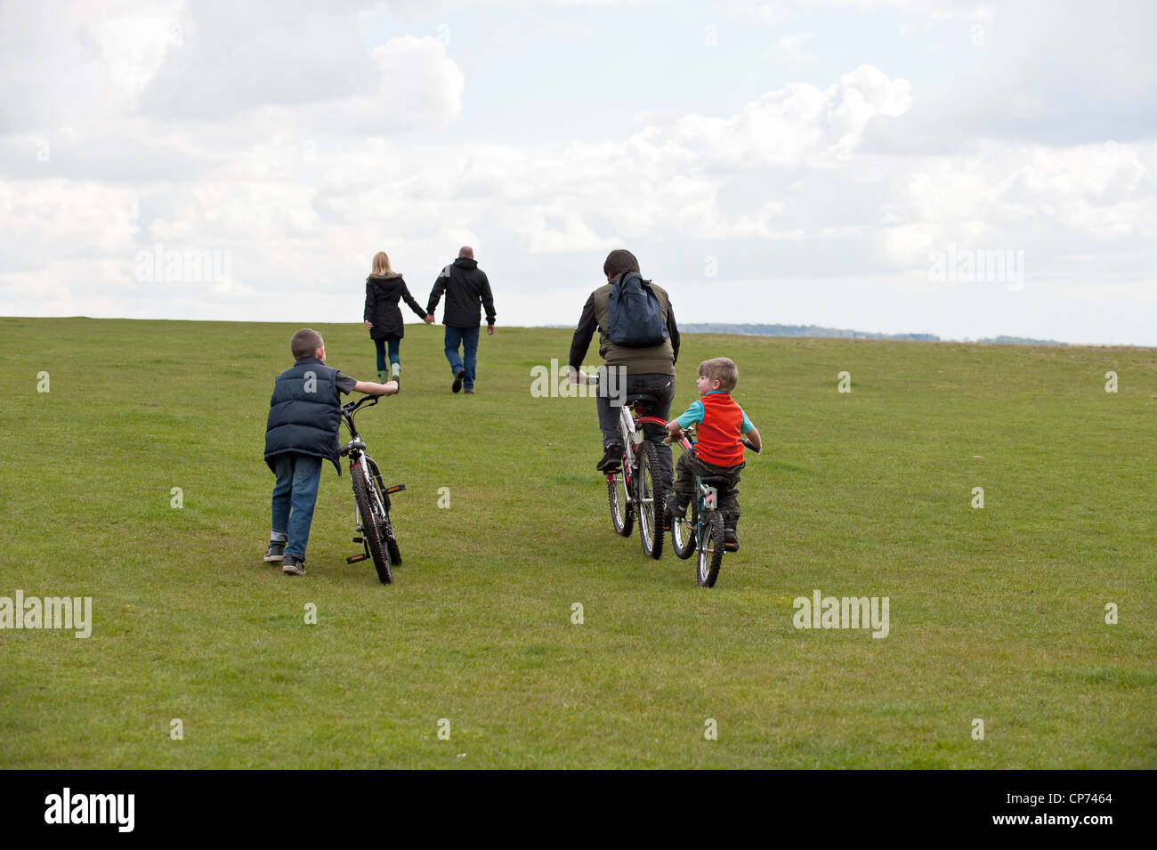 Menschen wandern und Radfahren über eine Wiese Stockfoto