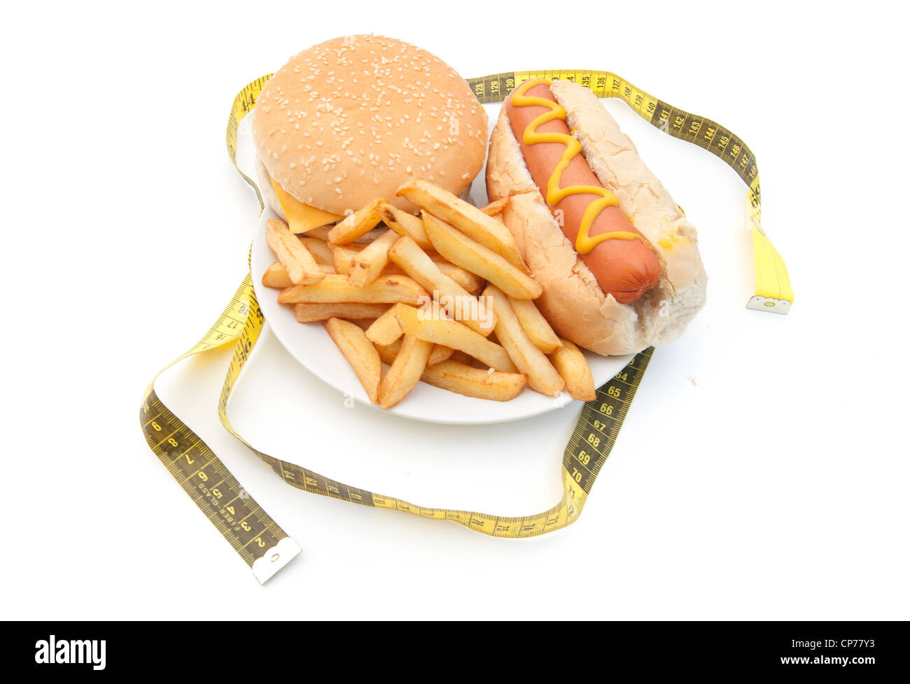 Maßband um eine Platte mit einem Cheeseburger, Pommes und Hot dog Stockfoto