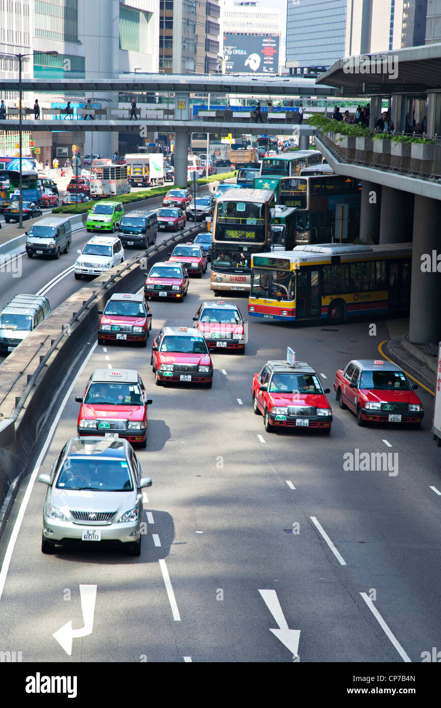 Taxis, Busse und andere Fahrzeuge auf den Straßen Hong Kongs am frühen Morgen Rush hour. Stockfoto
