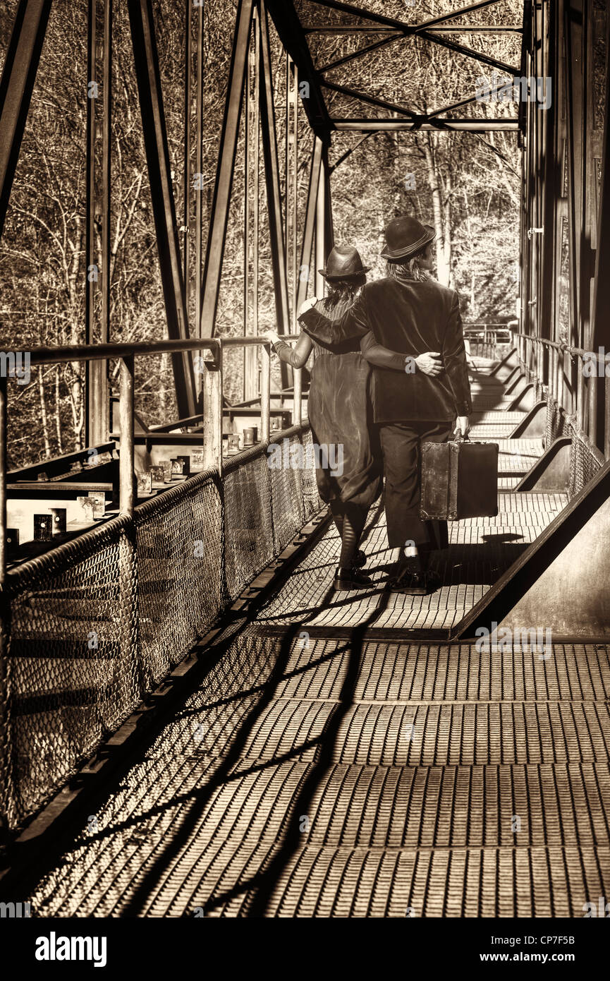 ein Vagabund paar geht auf einen alten Koffer auf eine alte Eisenbahnbrücke Stockfoto