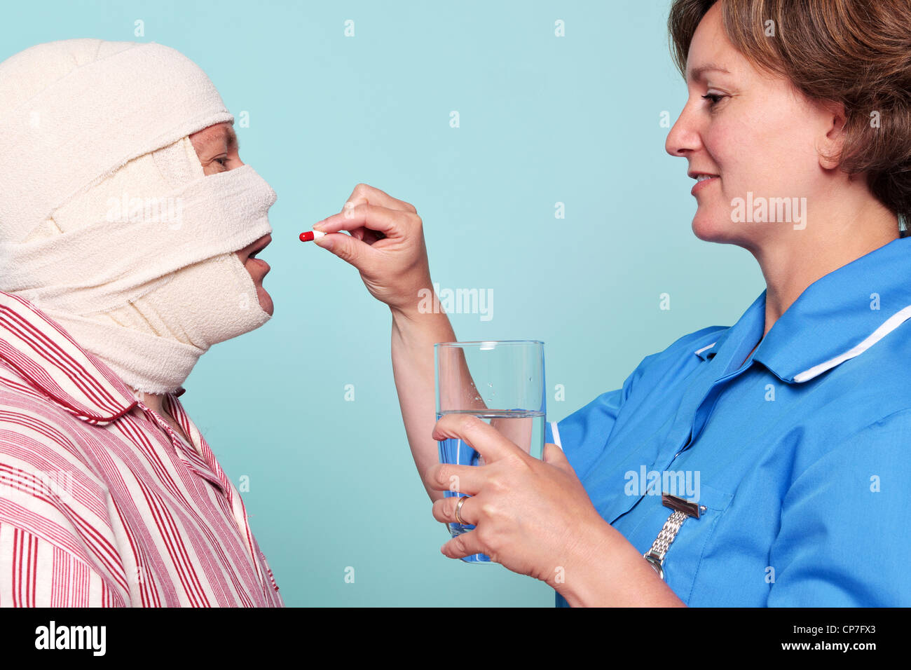 Foto von einer Krankenschwester, einem Patienten ein Medikament in Form einer Pille geben. Stockfoto