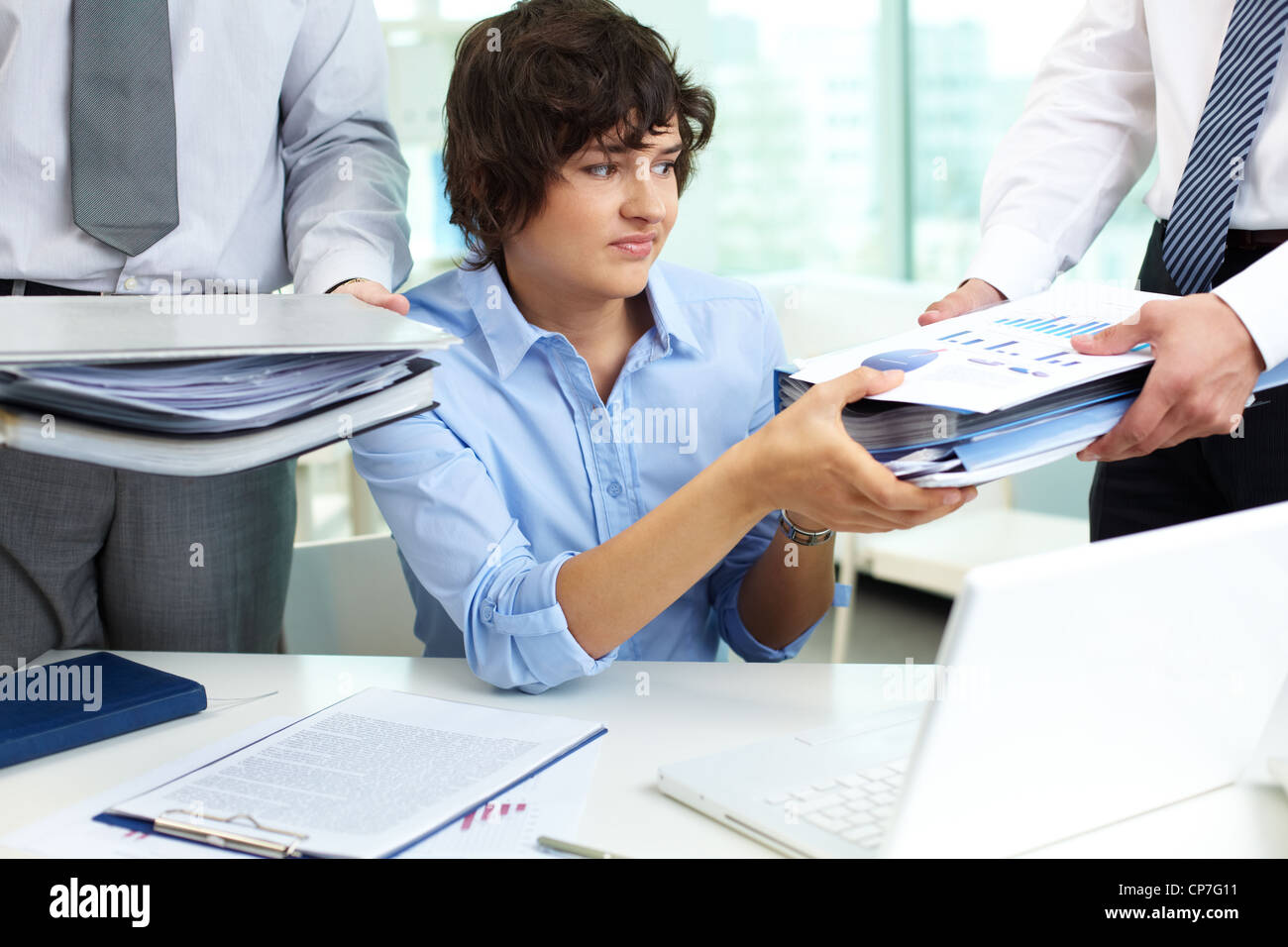Verwirrt Buchhalter unter grosser Haufen von Papieren Stockfoto