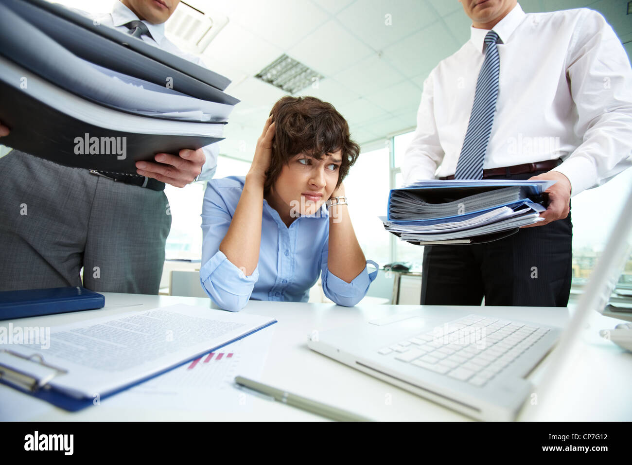 Verängstigte Sekretärin berühren den Kopf beim Betrachten der großer Haufen von Papieren Stockfoto