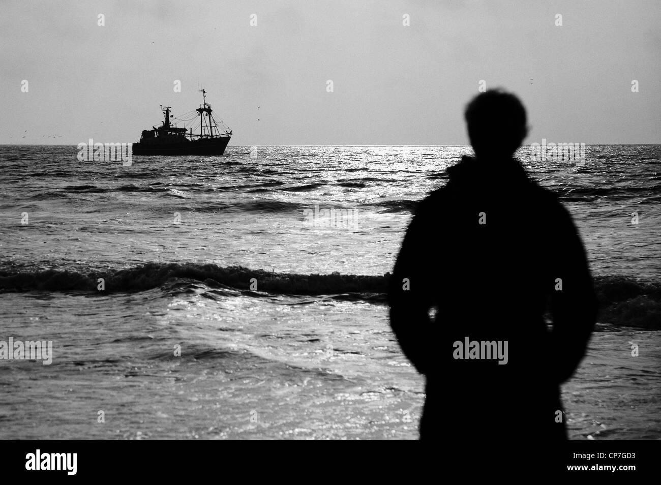 Frau, die gerade ein Fischerboot entlang der Küste von Noordwijk-Niederlande Stockfoto