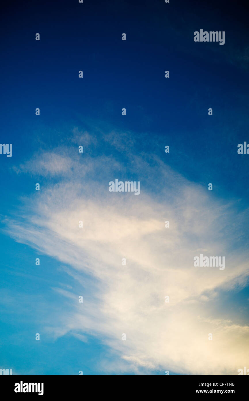 Weiße Sonnenuntergang Wolken über eine klare Dämmerung blauen Himmel Stockfoto