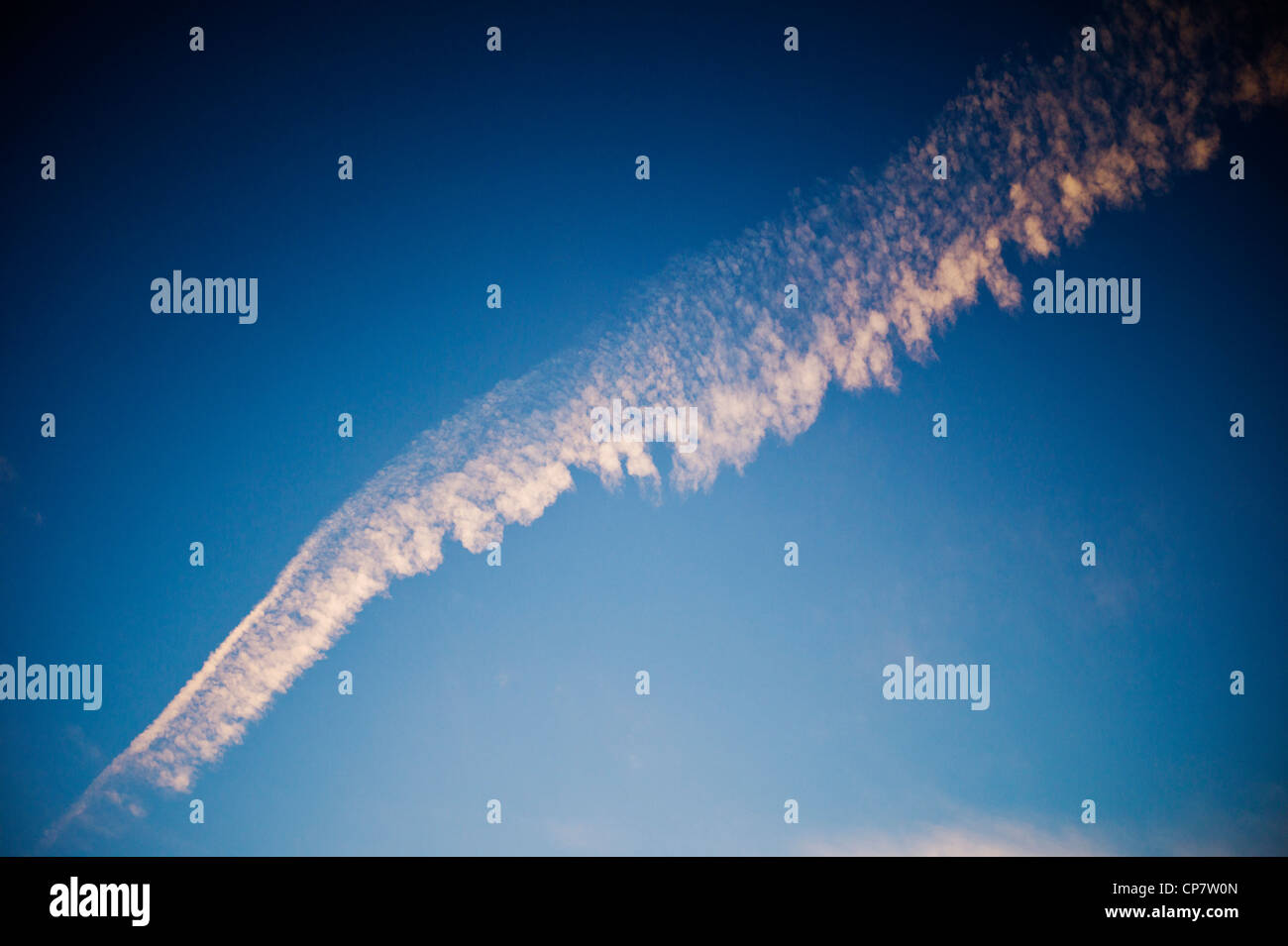 Kommerzielle Fluggesellschaft Jet Kondensstreifen über eine klare Dämmerung Sonnenuntergang blauen Himmel Stockfoto
