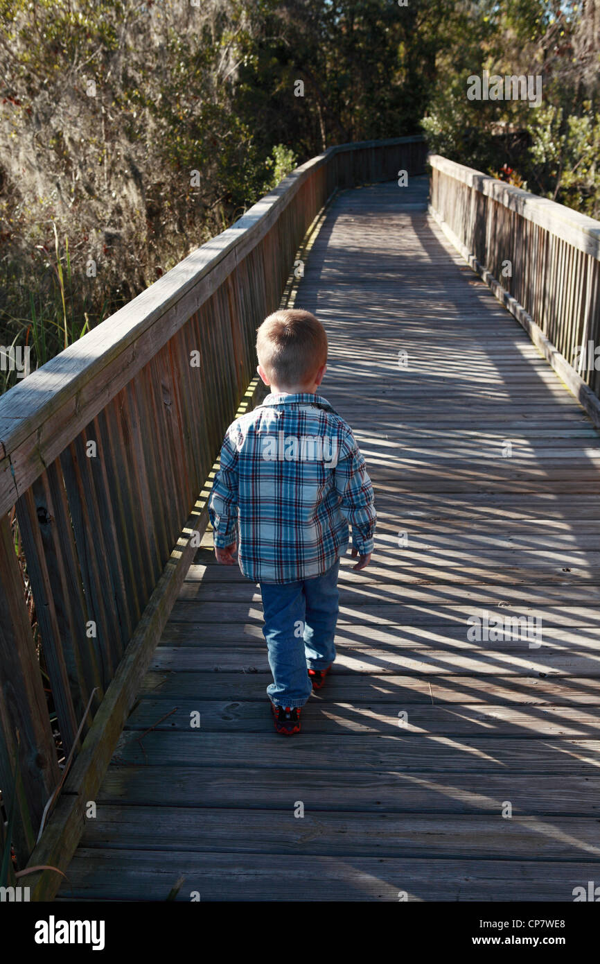 Ein Kind ist ein Weg in den Wald gehen.  Dieses Bild könnte verwendet werden, um eine ungewisse Zukunft für Kinder zu veranschaulichen. Stockfoto