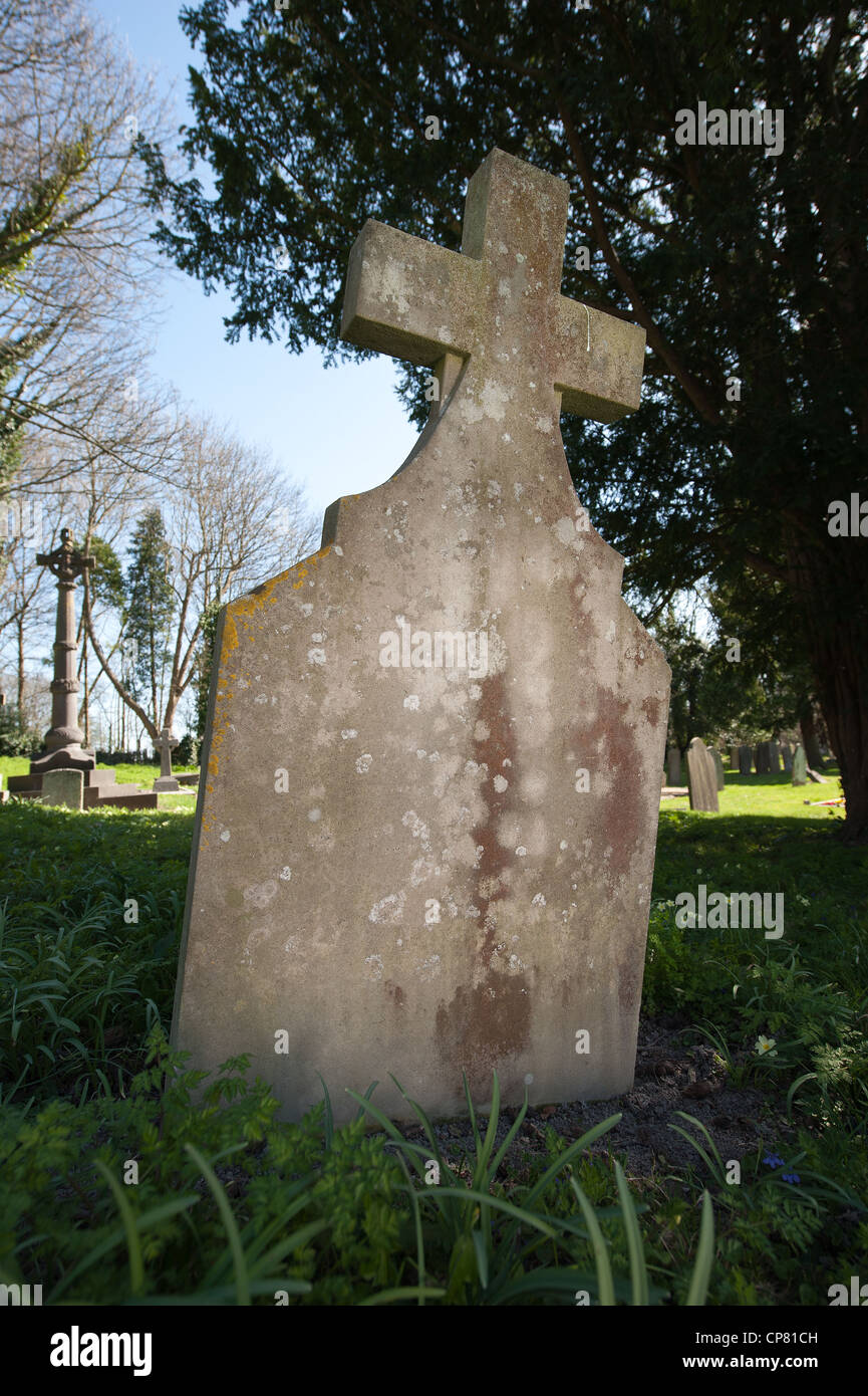 Grabstein mit ein Kreuzsymbol in der anglikanischen Kirche Friedhof hebt sich vom Hintergrund Stockfoto
