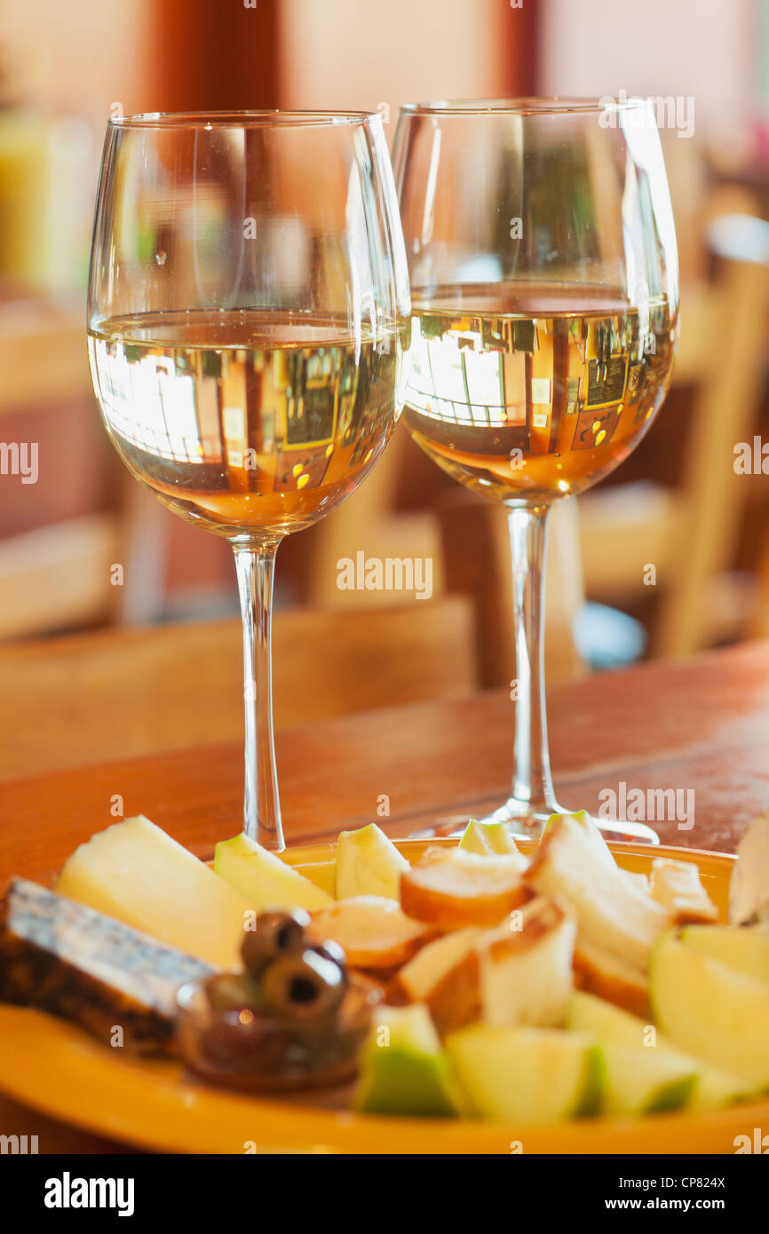 zwei Gläser weiß Wein mit Obst & Käse Platte, Wine Rack Store, Ventura, California Stockfoto