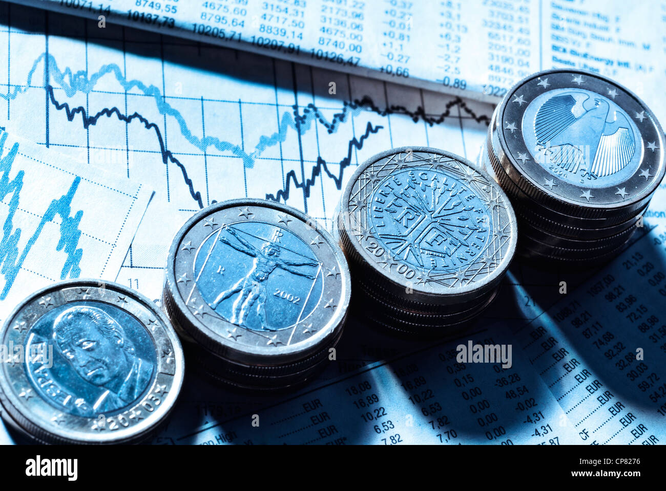 €-Münzen mit den Symbolen der Eurozone Länder Deutschland, Frankreich, Italien und Spanien sowie Tarifpreistabellen und Diagramme. Stockfoto