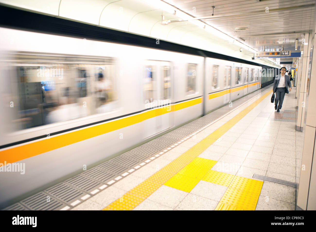 Mann zu Fuß auf der Plattform von einer u-Bahnstation Tokio, Japan. Stockfoto