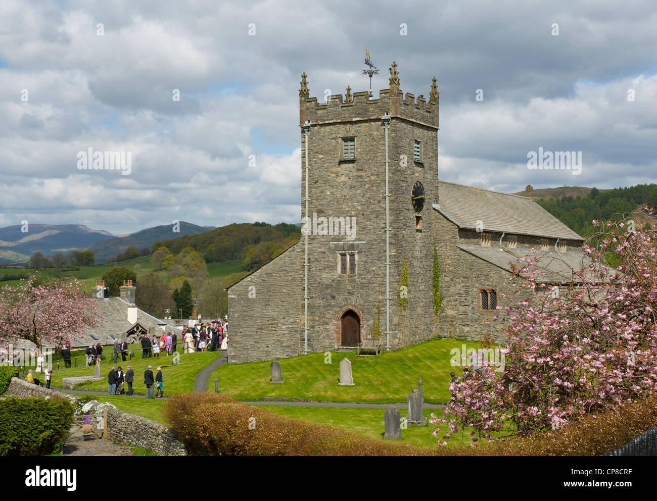 Hochzeitsgäste, die aus St. Michael Kirche, in dem Dorf Hawkshead Nationalpark Lake District, Cumbria, England UK Stockfoto