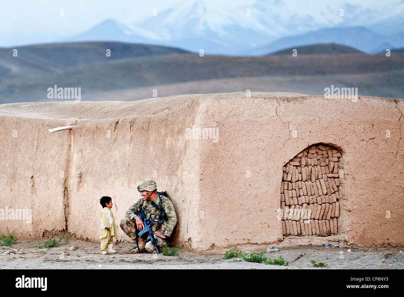 Ein US-Fallschirmjäger mit der 82. US-Luftlandedivision plaudert mit ein afghanischer Junge während einer Clearing-Operation 28. April 2012 in der Provinz Ghazni, Afghanistan. Der Soldat Studium der paschtunischen Sprache vor seinem Einsatz zum südlichen Ghazni. Stockfoto