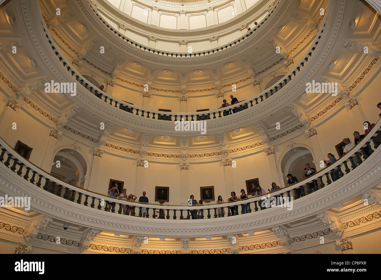 Menschen in den oberen Ebenen der Texas State Capitol Rotunde blicken einer Band-Performance auf der Eingangsebene. Stockfoto